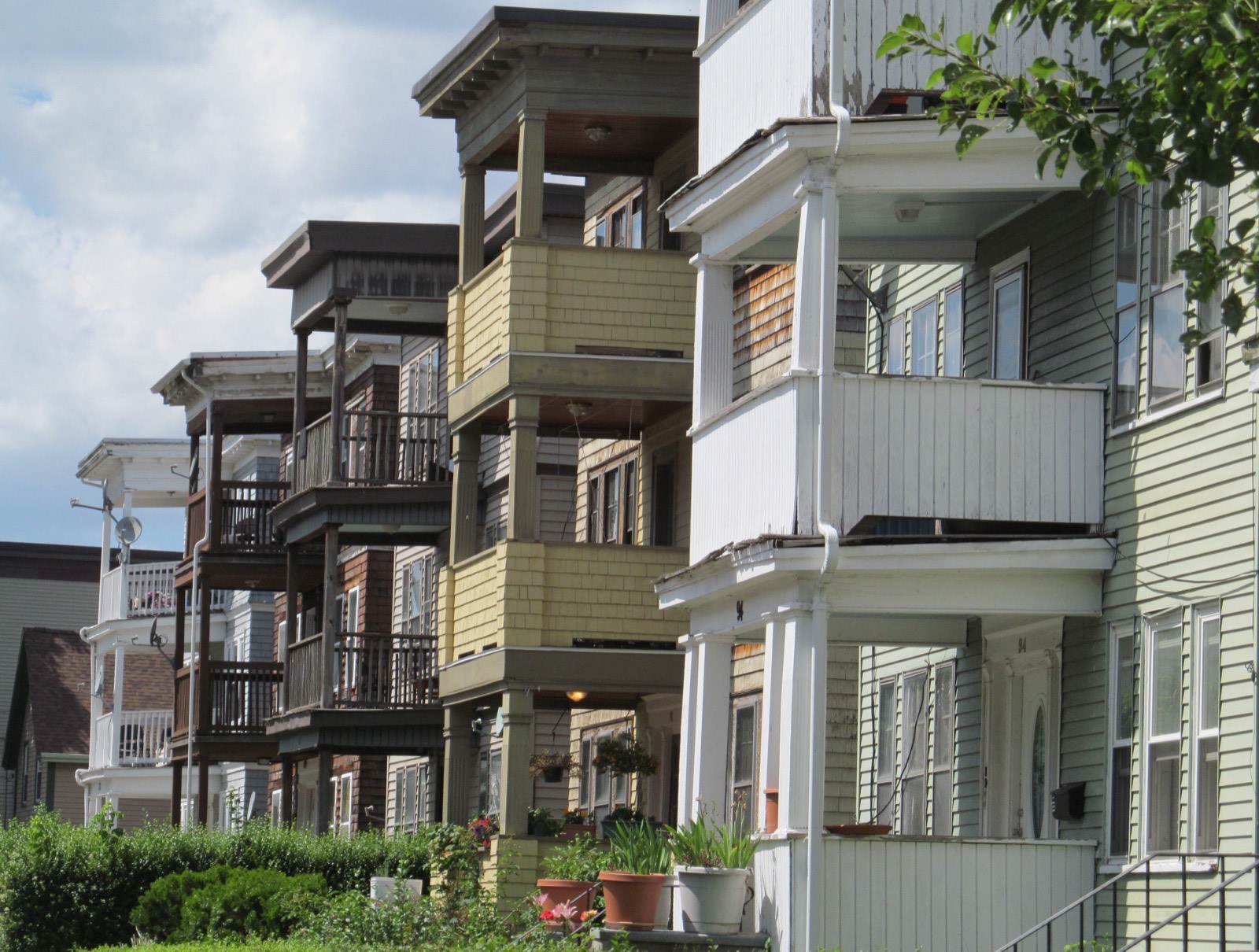 A run of Dorchester triple-deckers with stacked front porches, a common setting for a Boston bathroom renovation