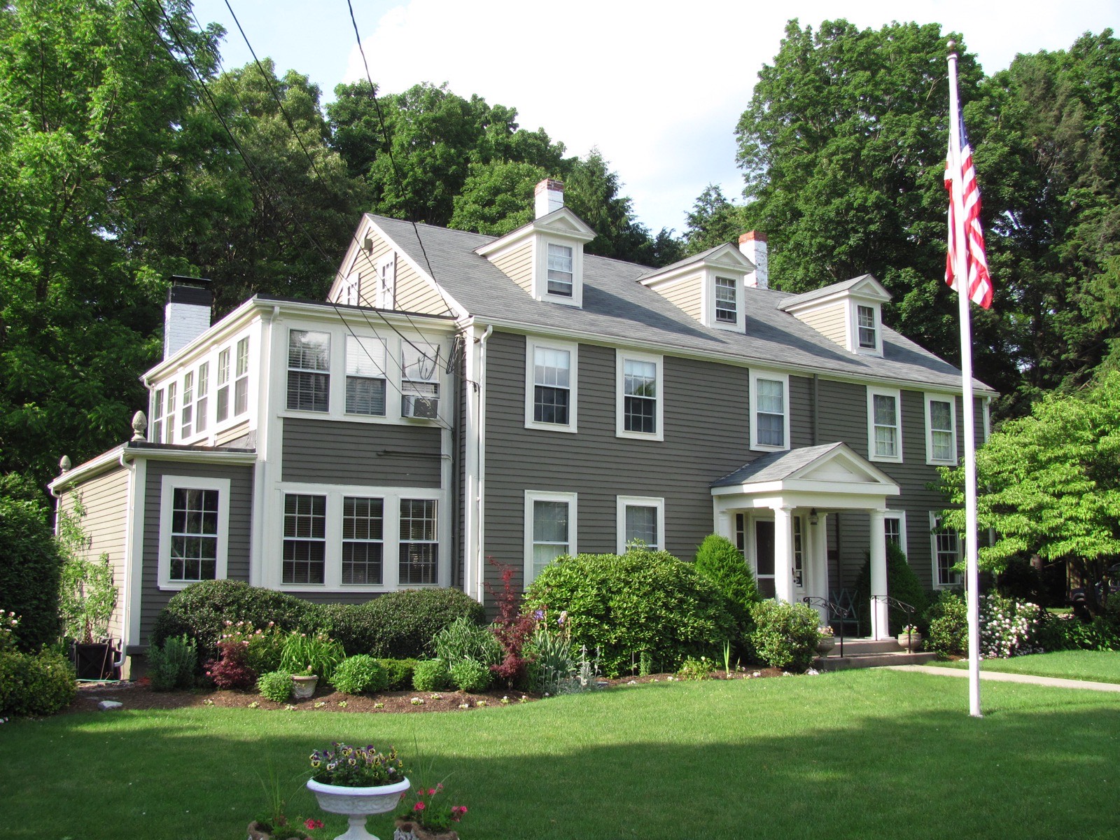A Needham Colonial with a later side wing and enclosed porch, the kind of added-to house most Needham bathroom remodeling happens in